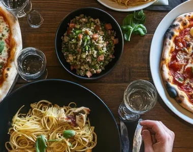 Pizza and pasta catering setup with variety of dishes for event