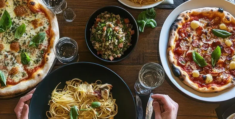 Pizza and pasta catering setup with variety of dishes for event